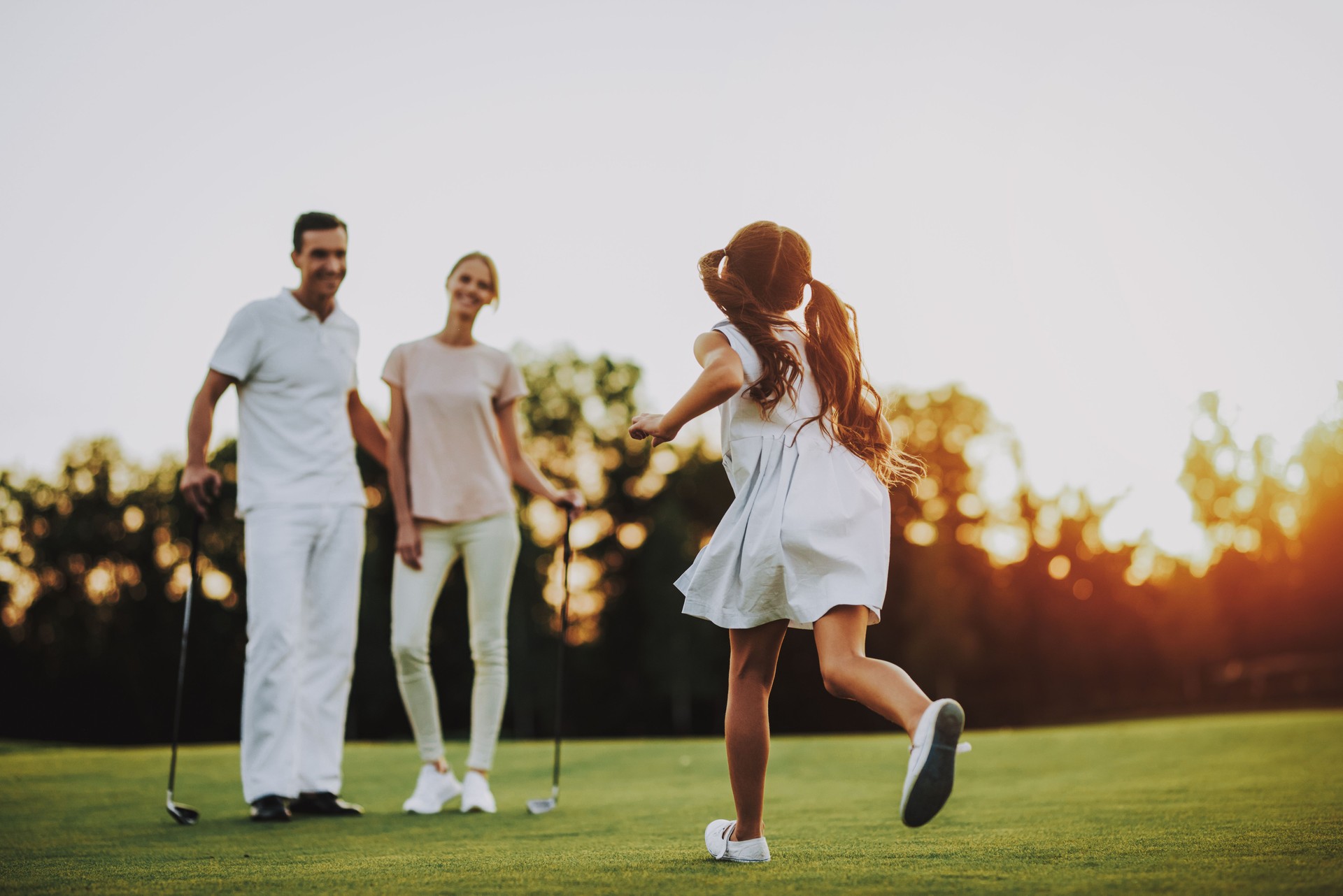 Happy Young Family Relax on Golf Field in Summer.